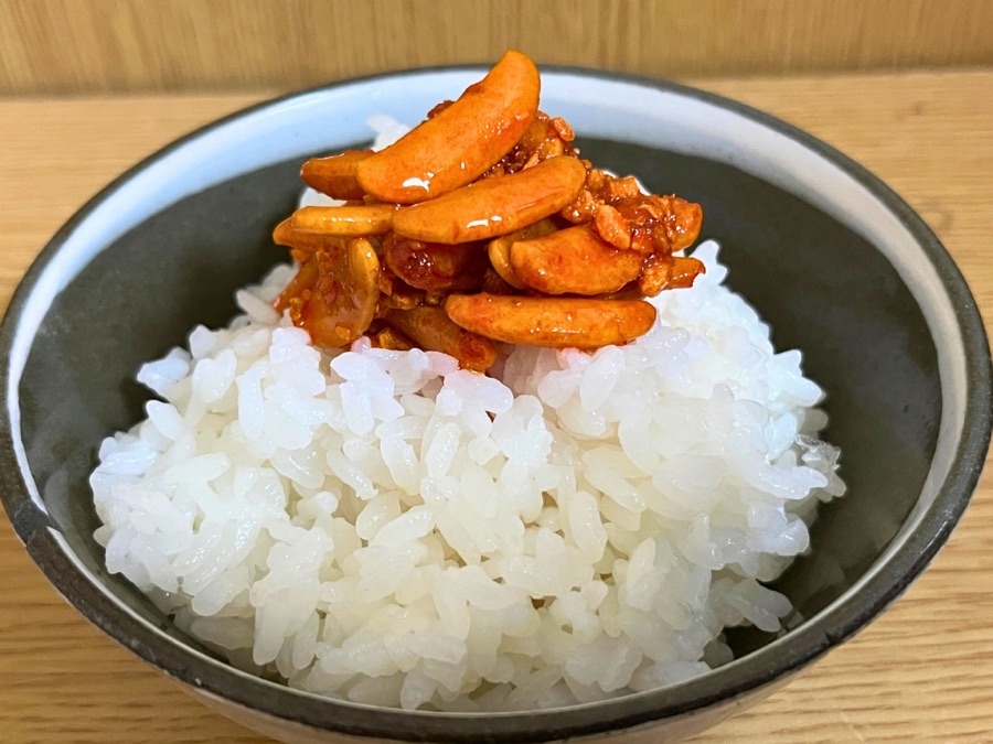 柿の種のオイル漬けをご飯にのせたところ