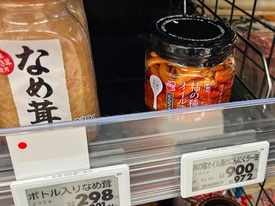 イオンスーパー新発田中田店の瓶詰めコーナー なめ茸の隣に並ぶ柿の種のオイル漬け